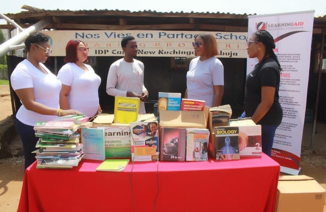 Textbooks arranged on a red table at New Kuchigoro IDP camp, Abuja.